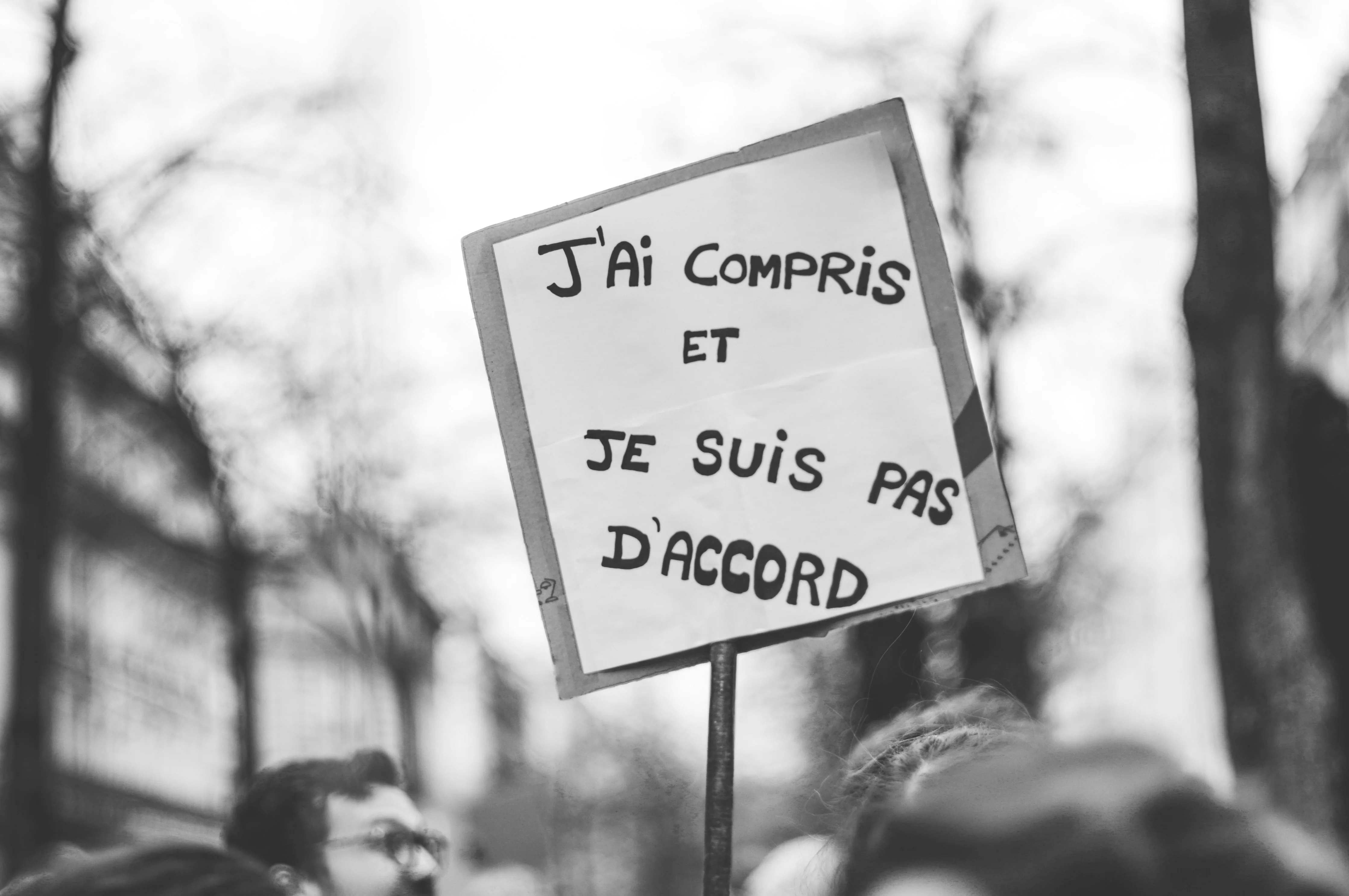 A hand-written protest sign in French reading 'J'ai compris et je suis pas d'accord' — I understood and I don't agree