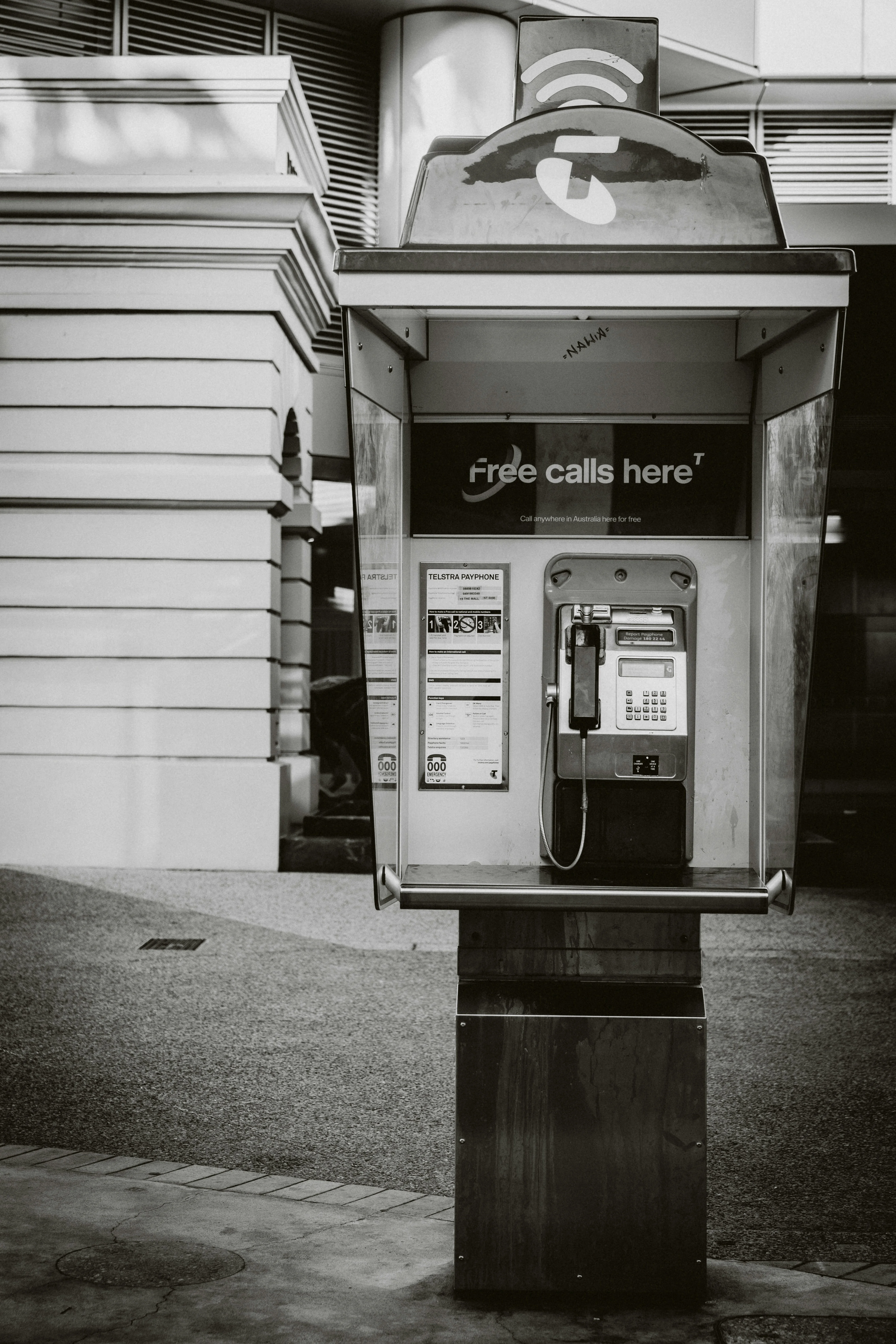 Vintage payphone booth with 'free calls here' sign.